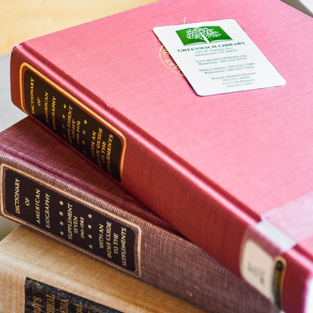 A stack of books with a library card on top