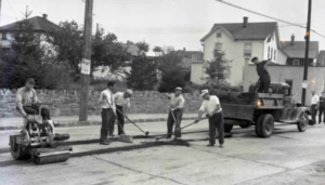 Workman covering the former trolley tracks along Hamilton Avenue using an asphalt paver. Similar to the Chickahominy Blast.
