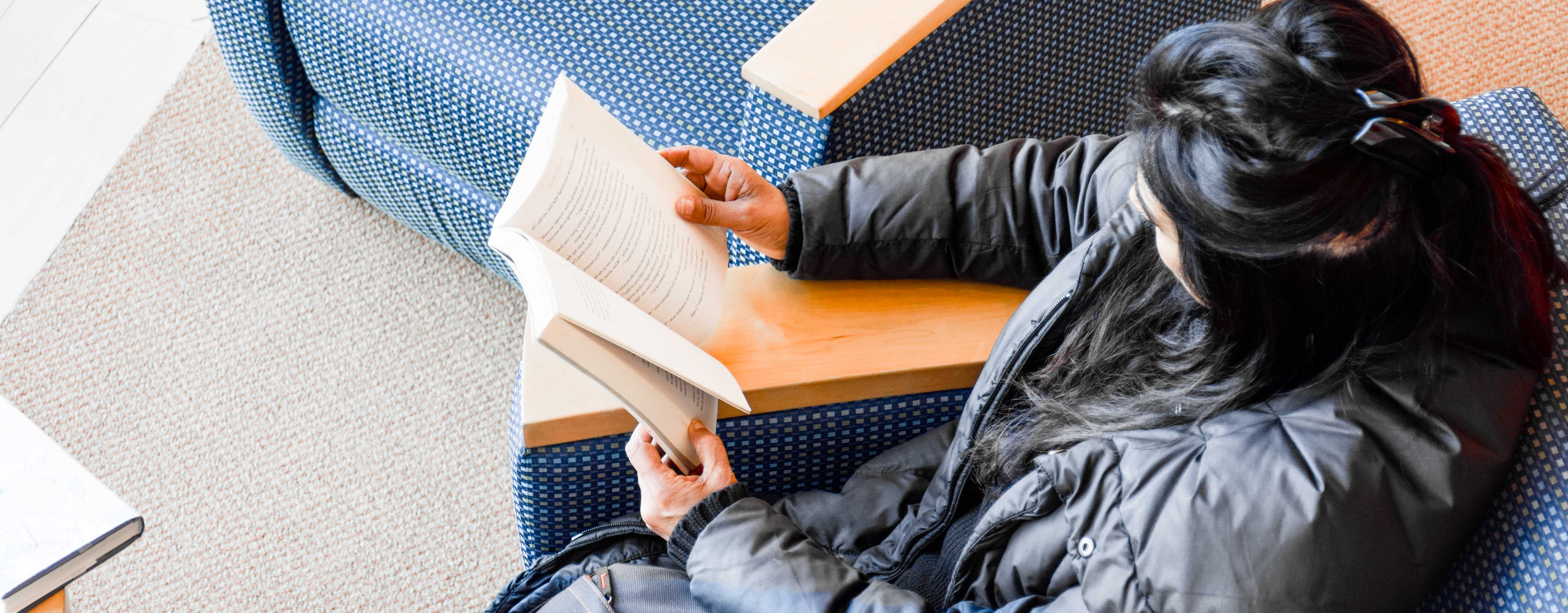 Patron reading a book at the Library