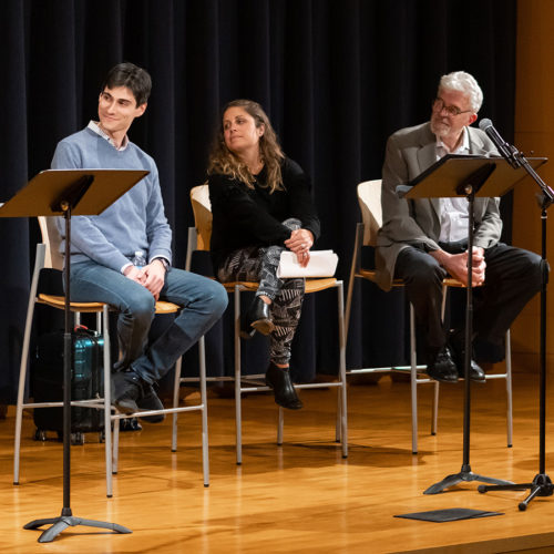 Three actors on stage for a library event